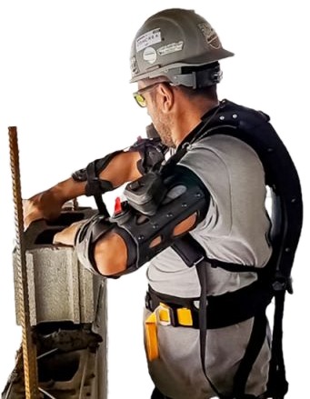 Maçon équipé d'un exosquelette Mawashi UPLIFT travaillant sur un mur de parpaings
